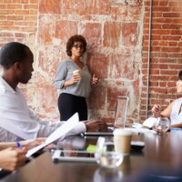 Mature Businesswoman Standing To Address Boardroom