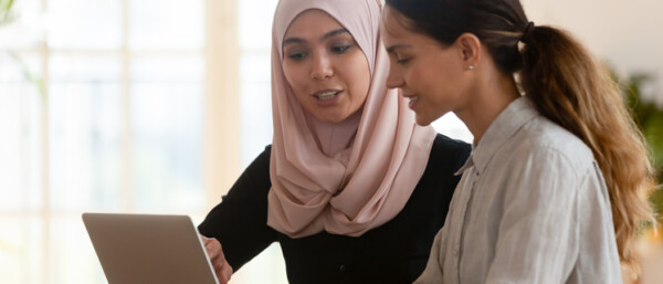 Two apprentices working together at a laptop.