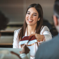 Young woman travel agent with flight tickets in hands