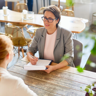 Owner of cafe interviewing young person