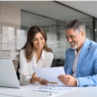 Male and female business partners checking document