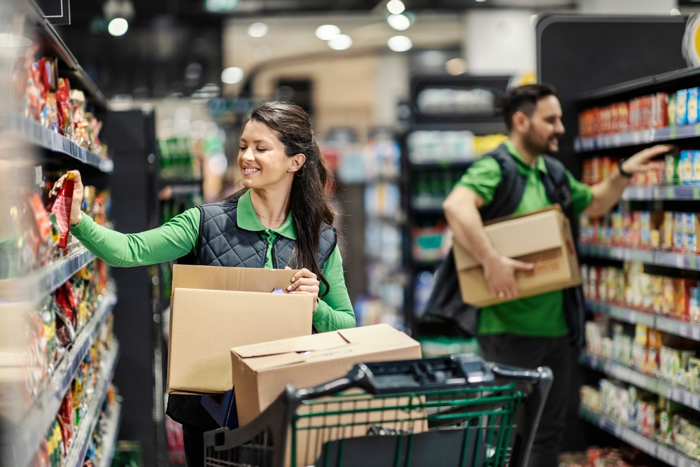 Retail employees putting products on shelves in supermarket
