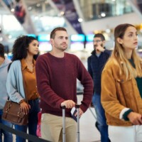 Travel, queue and wait with man in airport for vacation, international trip and tourism. Holiday, luggage and customs with passenger in line for airline ticket, departure and flight transportation