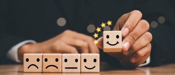 customer services best excellent business rating experience. Satisfaction survey concept. Hand of a businessman chooses a smile face on wood block circle. 5 Star Satisfaction.
