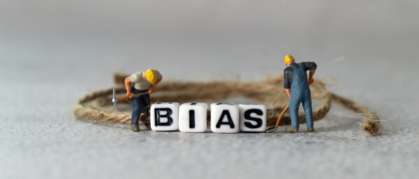 Business concept with white cube arranged in the word ’BIAS' and miniature people. The concept of not being prejudiced.