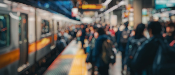 Blurred background of a busy subway station filled with commuters during the morning rush hour, showcasing the vibrant urban life and hustle of daily travel routines.