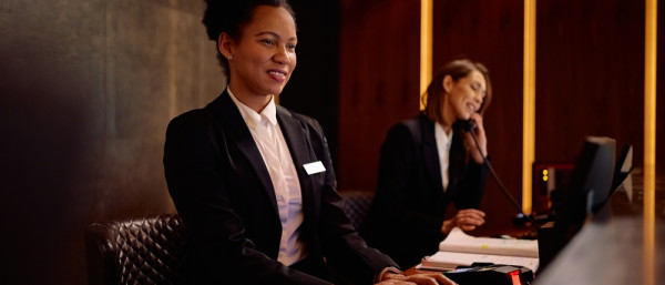 Receptionist working on a computer in a hotel.