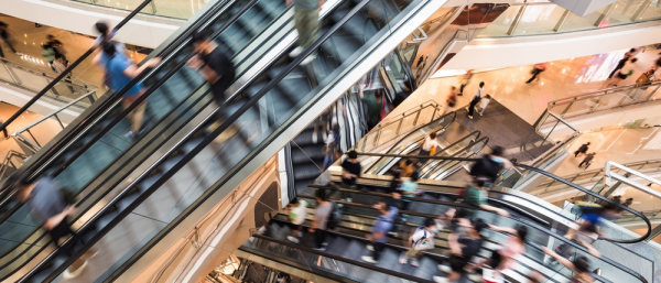 Motion blur people customer transport on escalator at urban shopping mall. Department store business, financial economy